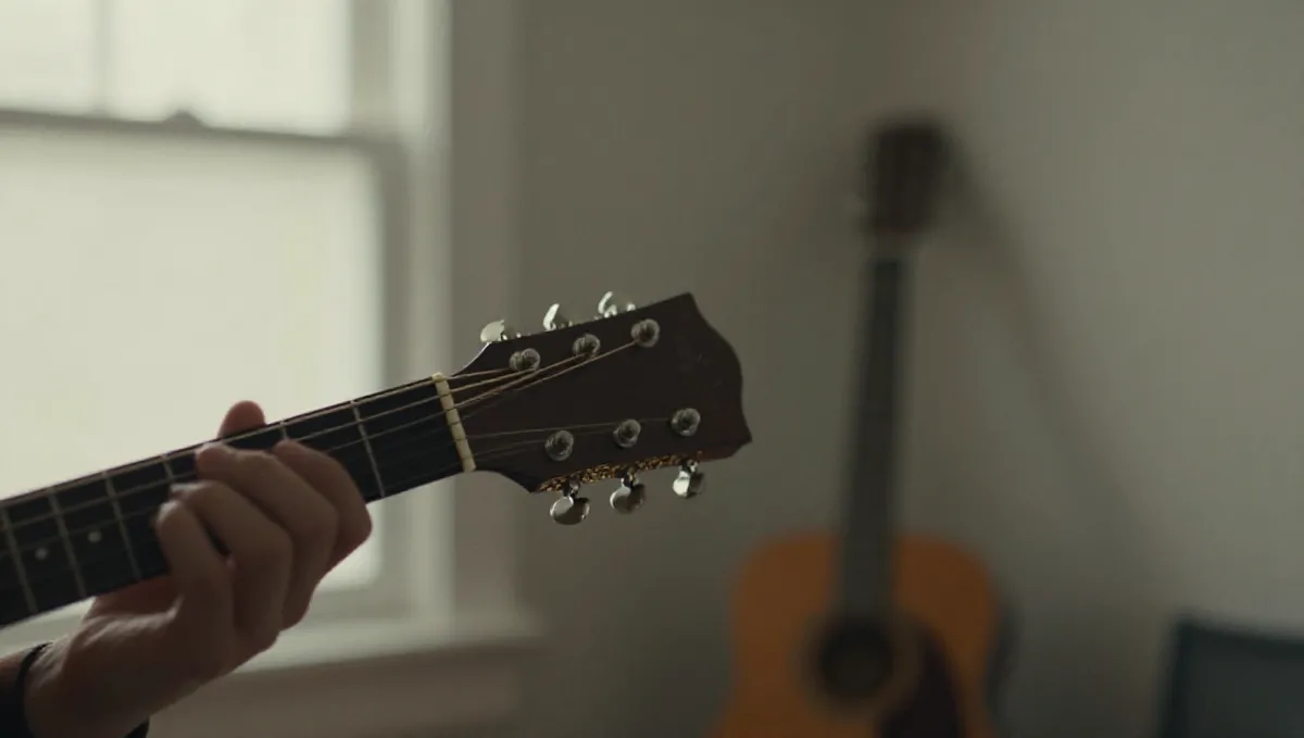 Cận cảnh bàn tay bấm hợp âm mở trên cần đàn guitar gỗ mộc