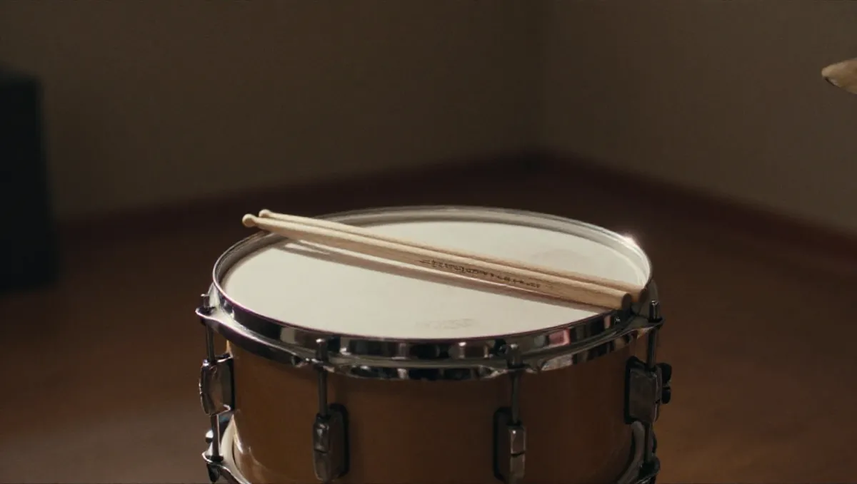 Trống snare và đôi dùi gỗ trong phòng tập, nơi tiếng trống đánh dấu phách